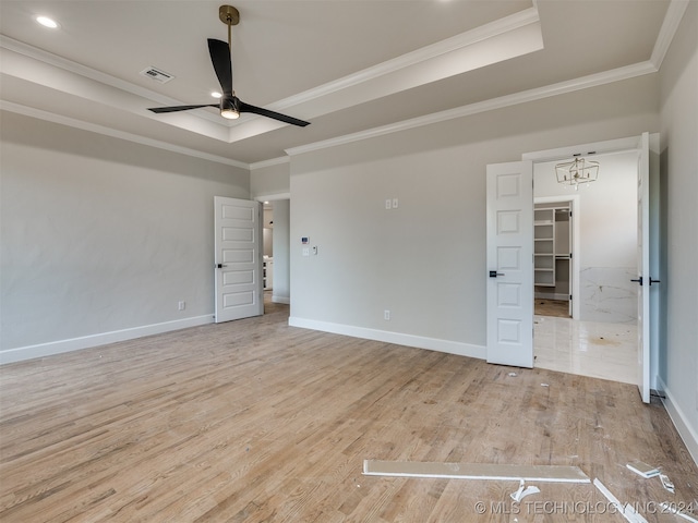 unfurnished room featuring ornamental molding, a tray ceiling, light hardwood / wood-style floors, and ceiling fan