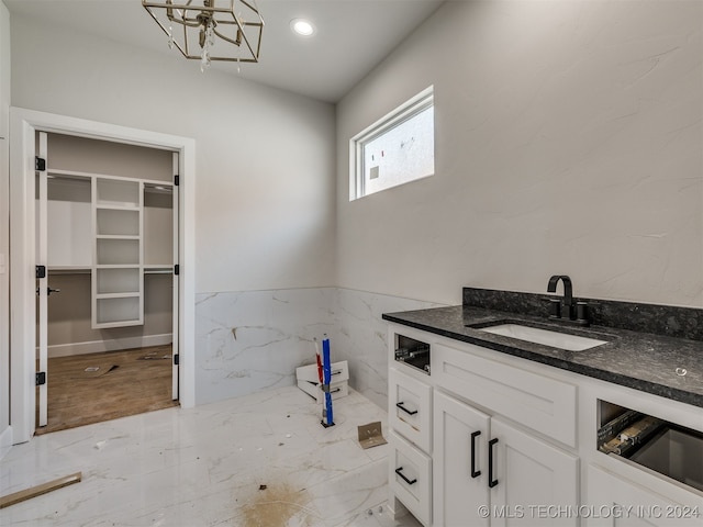 bathroom featuring an inviting chandelier, tile walls, and vanity