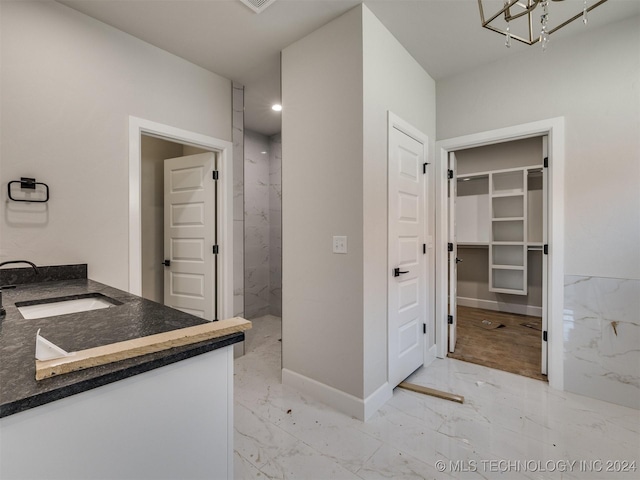 bathroom with baseboards, a chandelier, vanity, a marble finish shower, and marble finish floor