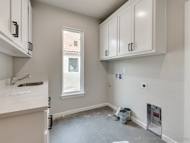 laundry area with washer hookup, sink, hookup for an electric dryer, hookup for a gas dryer, and cabinets