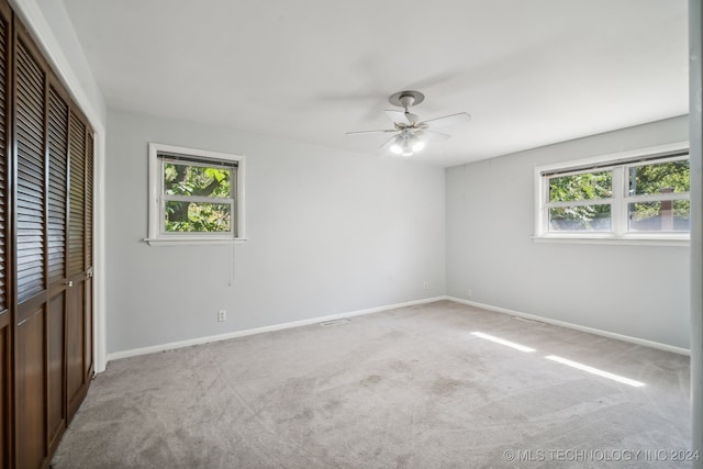 unfurnished bedroom with ceiling fan and light colored carpet