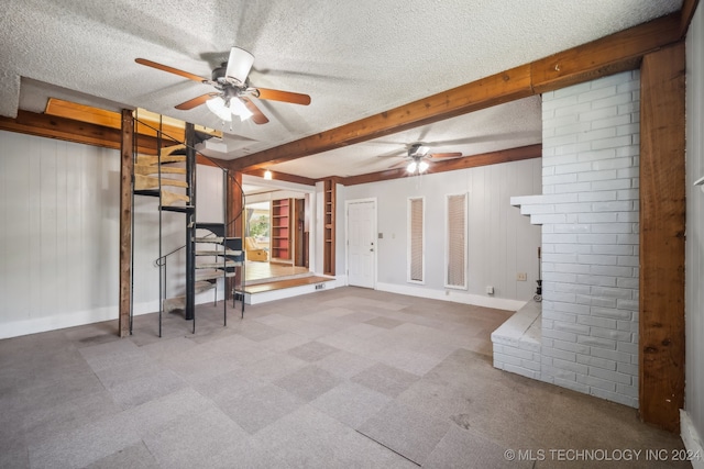 basement with wood walls, a textured ceiling, and ceiling fan