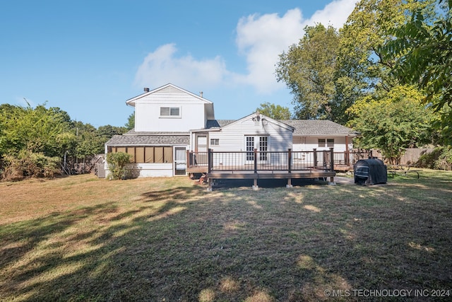 rear view of house featuring a deck and a lawn