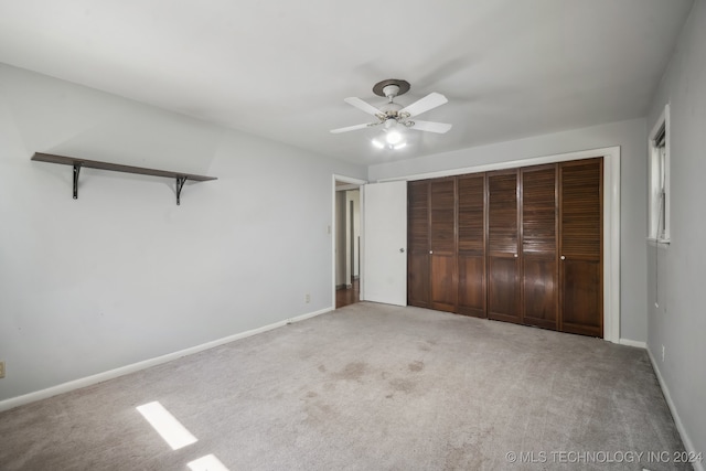 unfurnished bedroom featuring light carpet, ceiling fan, and a closet