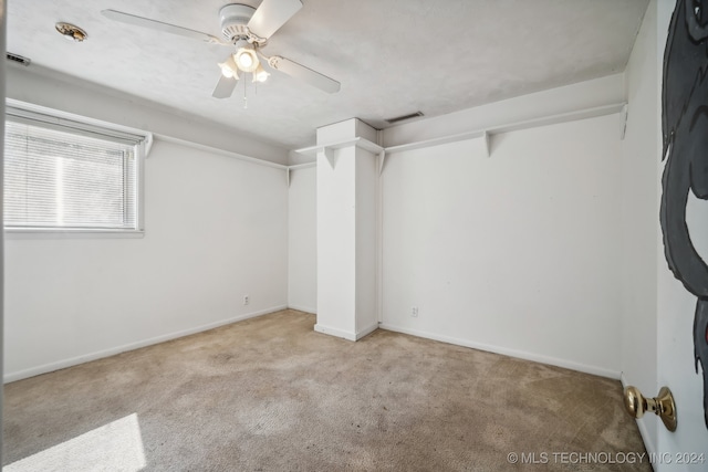 empty room with ceiling fan and light colored carpet