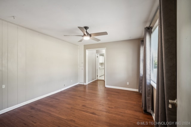 unfurnished room featuring ceiling fan and dark wood-type flooring