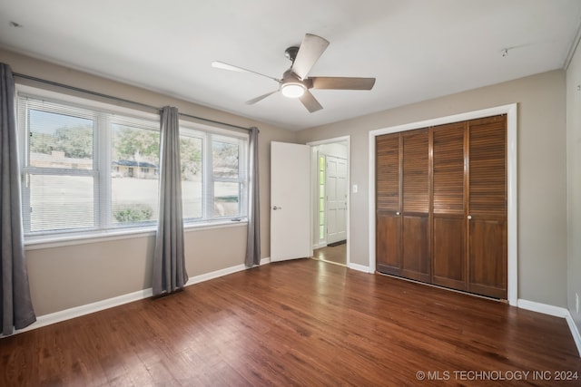 unfurnished bedroom featuring ceiling fan, a closet, and dark hardwood / wood-style flooring