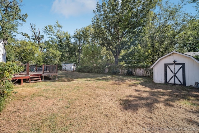 view of yard featuring a deck and a storage unit