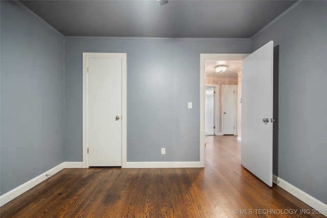 empty room with crown molding and dark hardwood / wood-style flooring