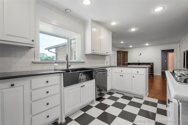 kitchen featuring backsplash, white cabinetry, dishwasher, and sink