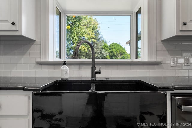 interior space featuring white cabinets and backsplash