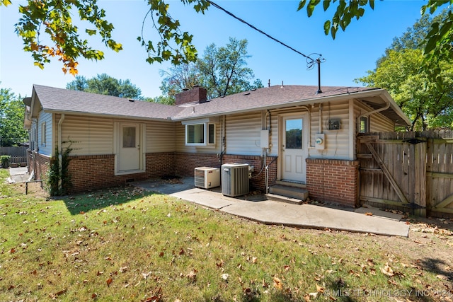 back of property featuring a lawn and central AC