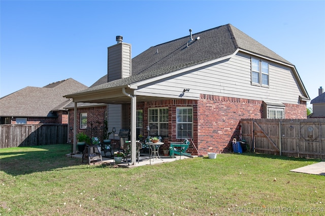 back of property with a lawn and a patio area