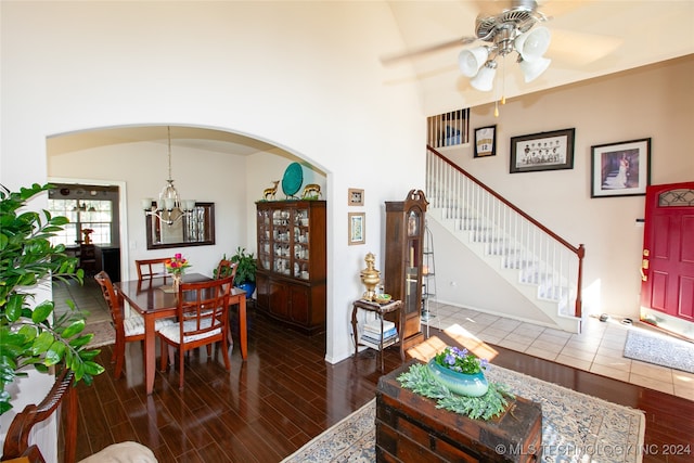 living room with ceiling fan with notable chandelier and dark hardwood / wood-style flooring