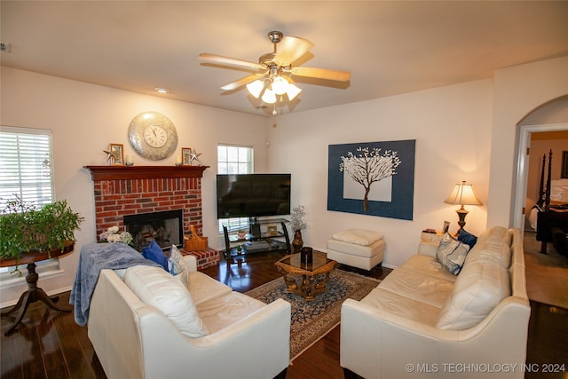 living room featuring a brick fireplace, ceiling fan, and dark hardwood / wood-style flooring