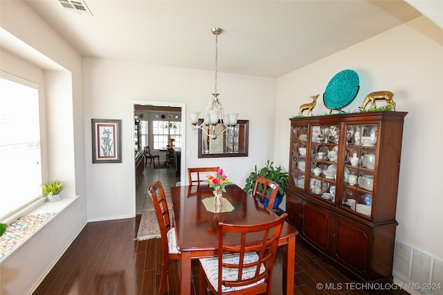 dining space featuring an inviting chandelier and dark hardwood / wood-style floors