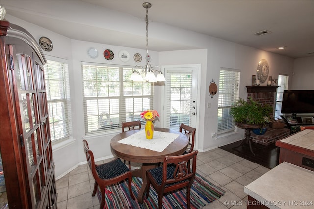 dining area with a notable chandelier, light tile patterned floors, and a wealth of natural light