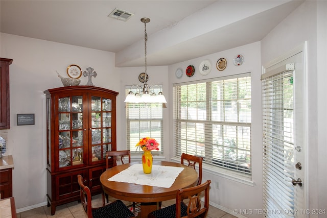 tiled dining room featuring a chandelier