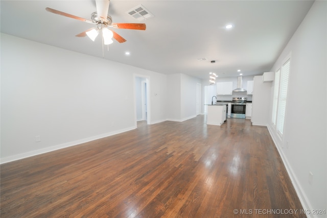 unfurnished living room featuring ceiling fan, sink, and dark hardwood / wood-style floors