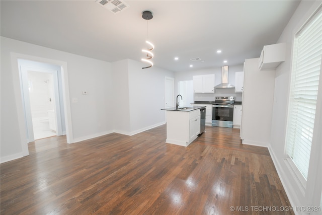 kitchen with hanging light fixtures, stainless steel appliances, wall chimney range hood, dark hardwood / wood-style floors, and white cabinets