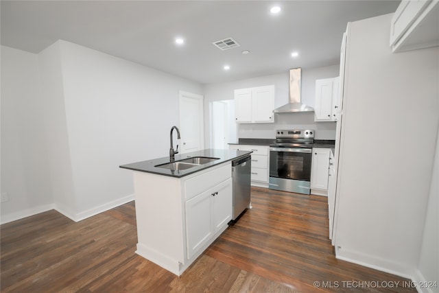 kitchen with appliances with stainless steel finishes, dark hardwood / wood-style flooring, sink, wall chimney range hood, and white cabinetry