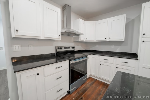 kitchen with electric stove, dark hardwood / wood-style flooring, white cabinets, and wall chimney range hood