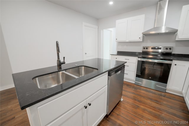 kitchen with dark wood-type flooring, a center island with sink, wall chimney range hood, sink, and stainless steel appliances