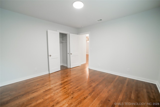 unfurnished bedroom with a closet and hardwood / wood-style flooring