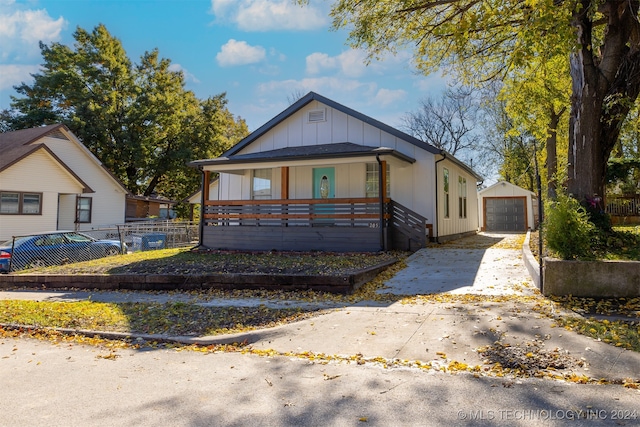 view of front of property featuring a porch, a garage, and an outdoor structure