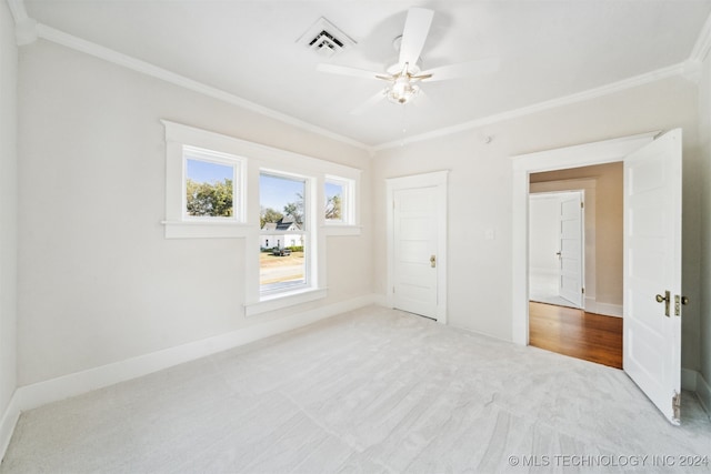 unfurnished bedroom featuring light carpet, crown molding, and ceiling fan