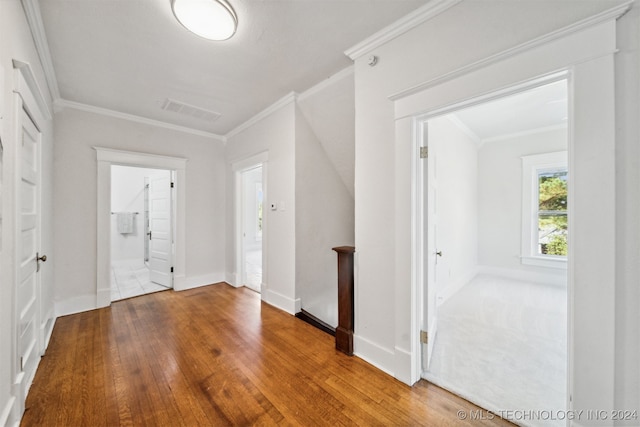 hall with ornamental molding and hardwood / wood-style floors