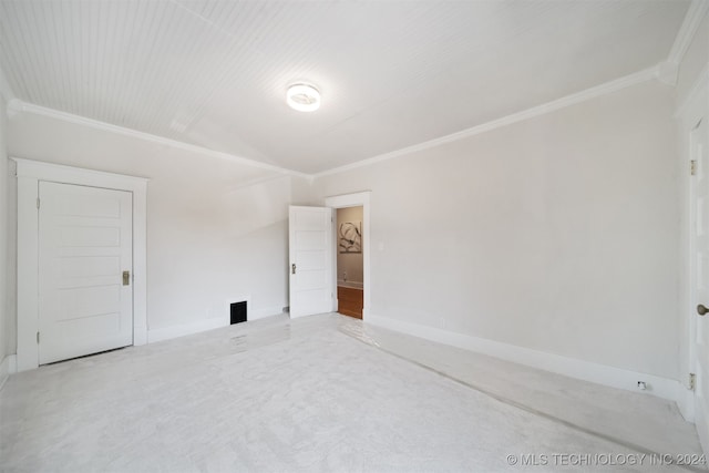 carpeted empty room featuring crown molding