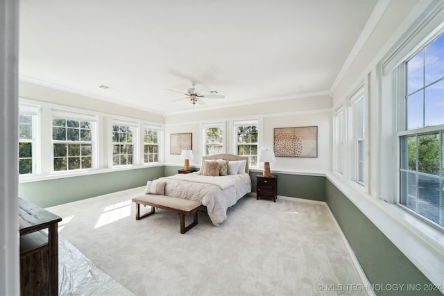 bedroom with ceiling fan, light carpet, and ornamental molding