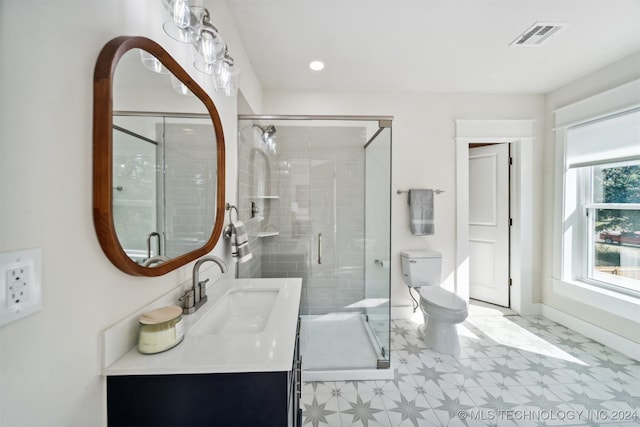 bathroom with an enclosed shower, vanity, and toilet