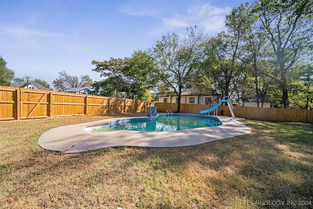 view of pool featuring a water slide and a lawn