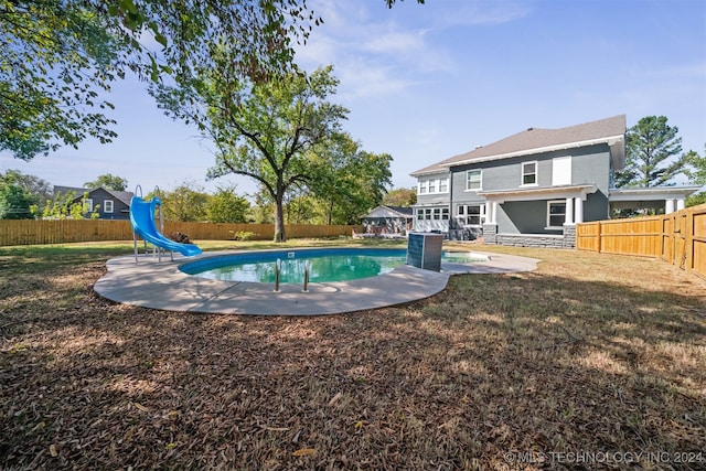 view of swimming pool with a water slide and a patio area