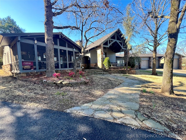 view of front facade featuring a garage and a sunroom