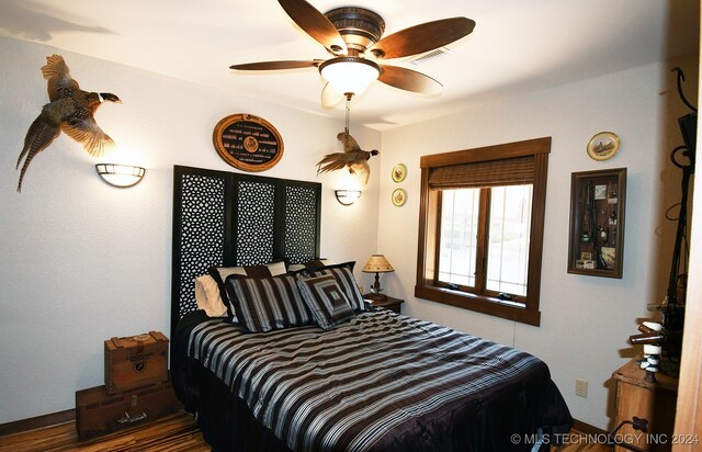 bedroom with ceiling fan and dark wood-type flooring