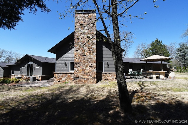 view of side of home with a patio and central air condition unit