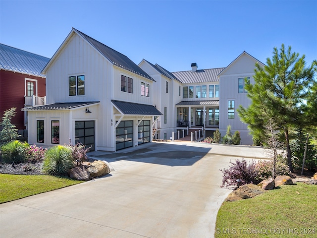 rear view of property featuring a garage and a lawn