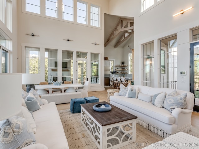 living room featuring a towering ceiling and light wood-type flooring