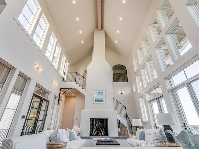 living room with beam ceiling and a towering ceiling