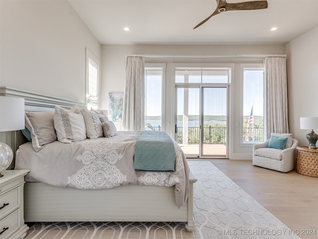 bedroom with light hardwood / wood-style floors, multiple windows, and access to exterior