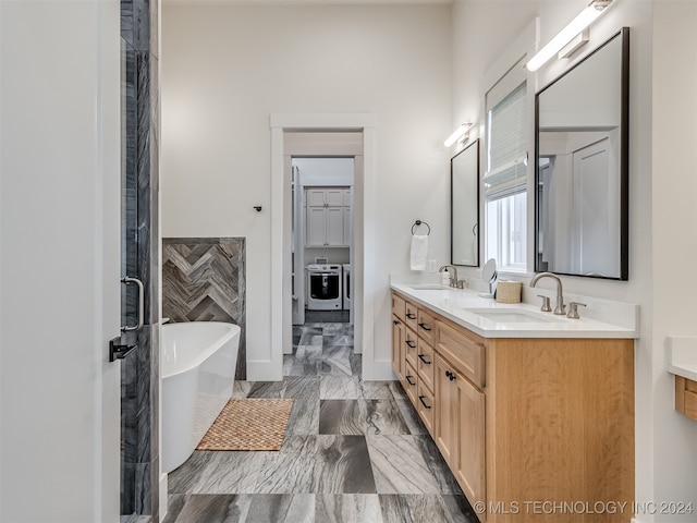 bathroom featuring vanity, washer and dryer, and shower with separate bathtub