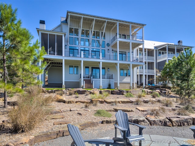 rear view of property featuring a porch and a balcony