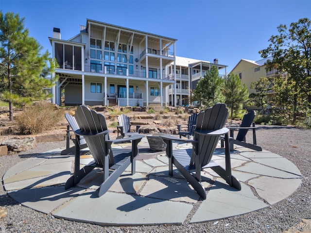 view of patio / terrace with an outdoor fire pit and a balcony