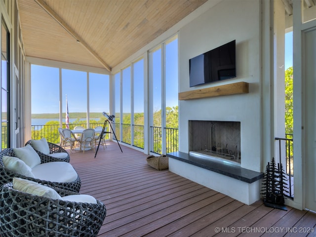 sunroom / solarium with plenty of natural light, wood ceiling, and a water view