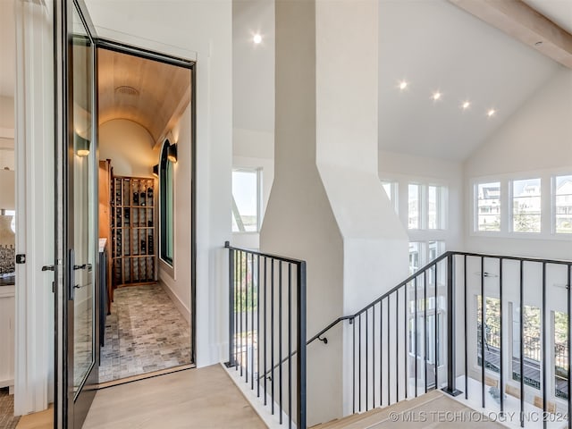 stairs featuring high vaulted ceiling and wood-type flooring