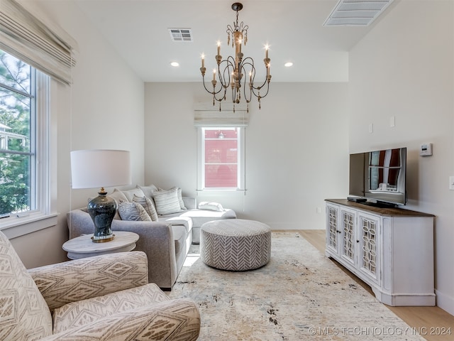 living room featuring a notable chandelier and light wood-type flooring