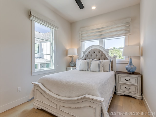 bedroom featuring light hardwood / wood-style flooring, multiple windows, and ceiling fan